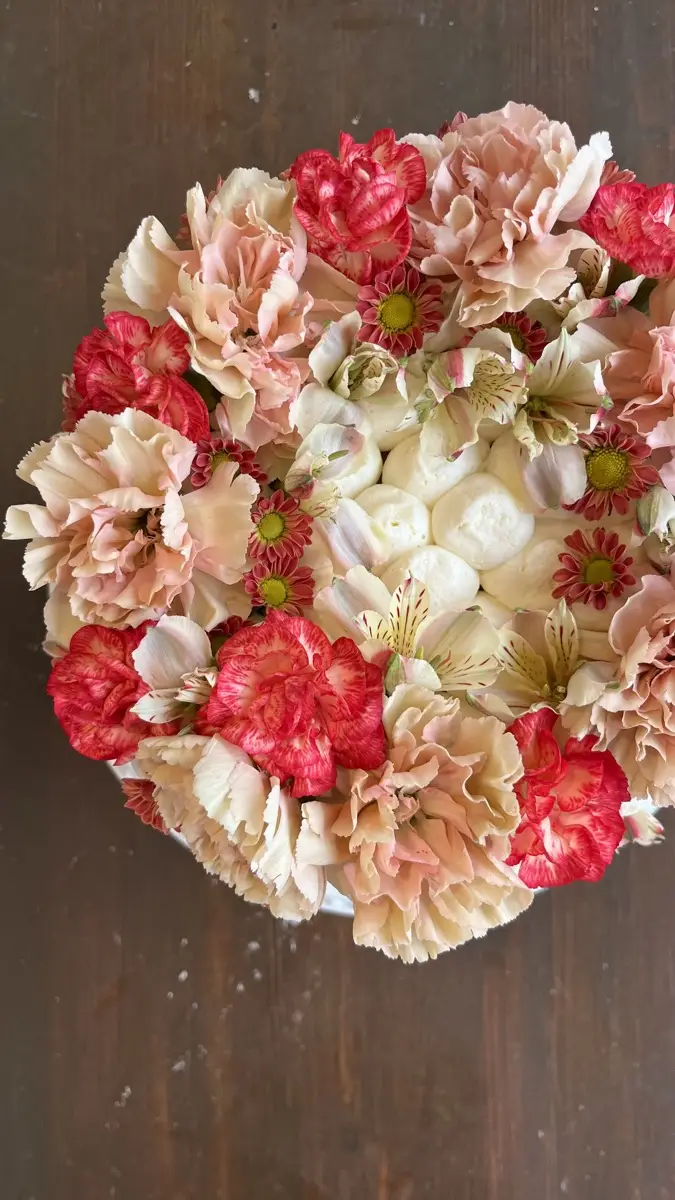Cake covered with pink and cream flowers