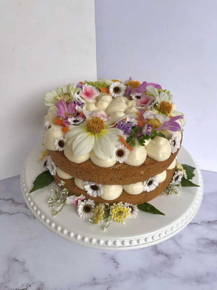 A Birdie’s layer cake with buttercream and colorful flowers